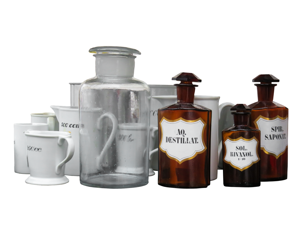 The image shows various old-fashioned bottles and jars, some labeled with terms like 