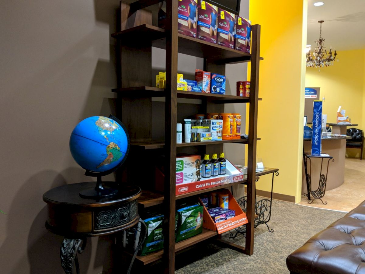 This image shows a room with a shelf stocked with various health and wellness products, a globe on a side table, and a yellow wall in the background.